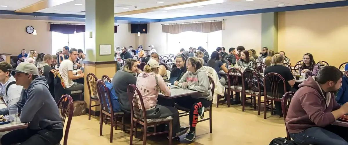 Students eating and sitting in dining hall room