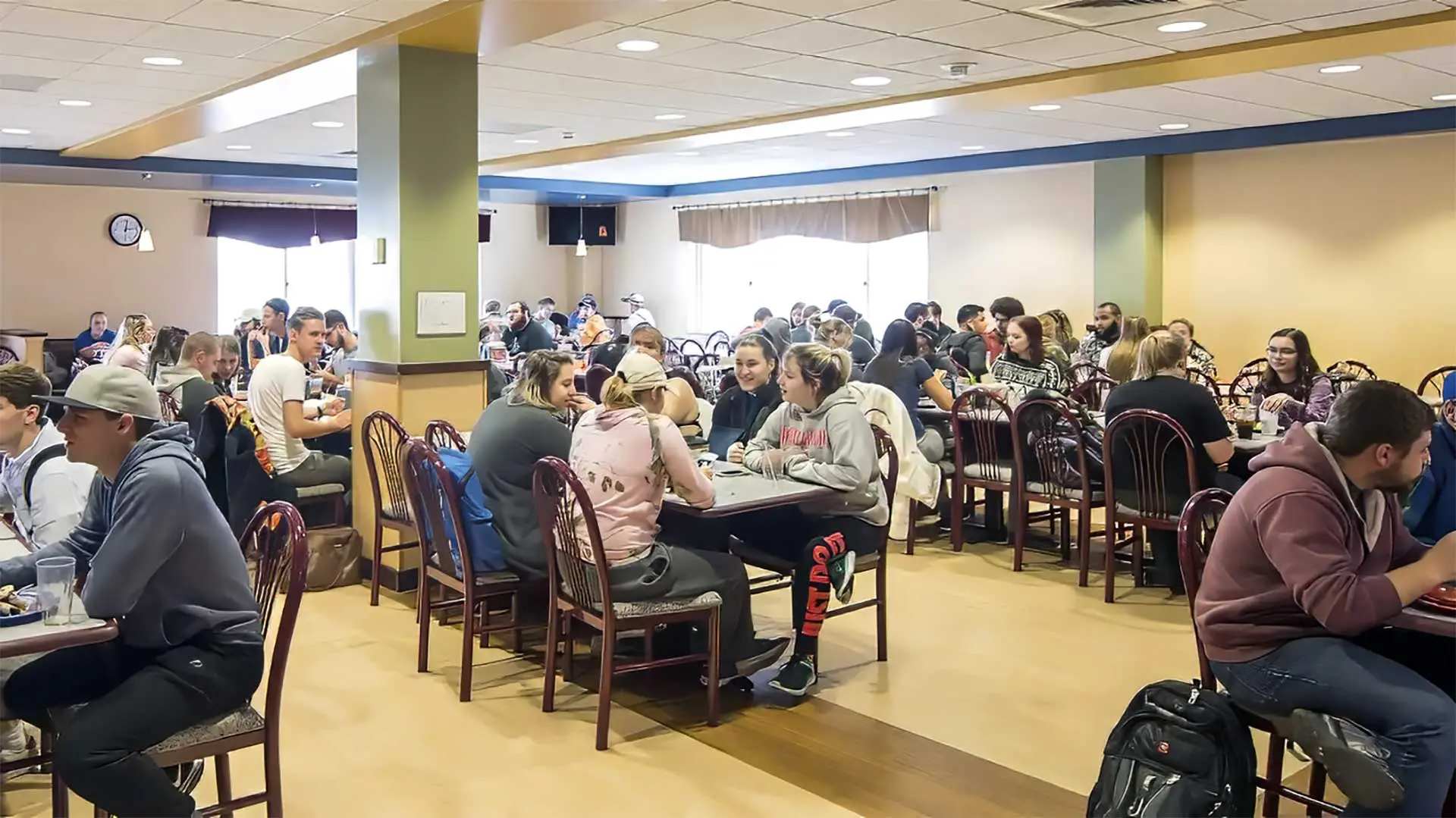 Students eating and sitting in dining hall room